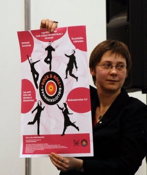 Ramunė Petuchovaitė pristato tinklaraščio Rock&roll bibliotekininkas plakatą Vilniaus knygų mugėje 2010.