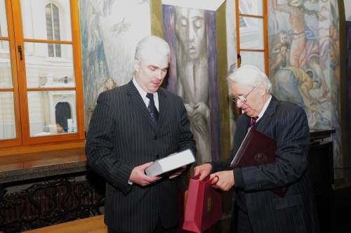 Po sutarties pasirašymo rektorius padovanojo svečiui neseniai išleistą naujausią Vilniaus universiteto istoriją. 