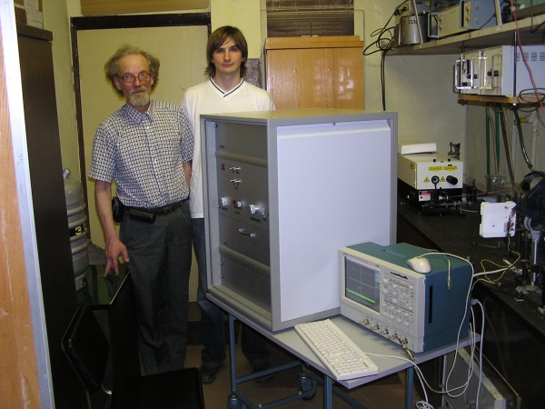 Habil.dr. E.Gaubas su doktorantu A.Ulecku laboratorijoje greta jų sukonstruoto prietaiso, skirto Didžijo hadronų kolaiderio detektorių modernizacijos darbams. Nuotr. iš katedros arch.