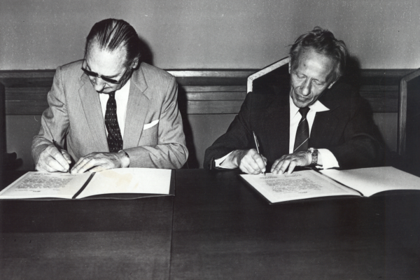 Dr. V. Dargužas (kairėje) perduoda žemėlapių kolekciją Vilniaus univeristetui, sutartį pasirašo ir rektorius akad. J.Kubilius, 1983 m. Nuotr. iš asm. akad. J. Kubiliaus albumo